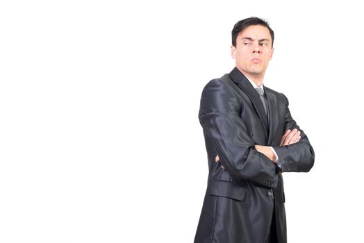 Side view of attentive young male entrepreneur with dark hair in formal outfit looking away with suspicion while standing against white background in studio