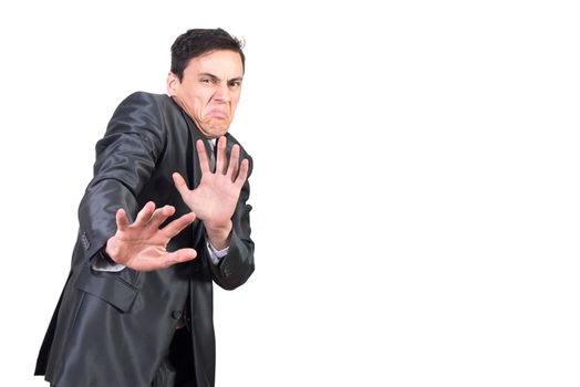 Squeamish young man with dark hair in elegant suit showing stop sign while looking at camera with disgust in face against white background