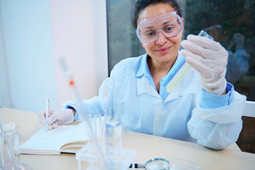 Multi-ethnic woman, lab technician, scientist testing the chemical experiment in hospital laboratory. Professional scientific pharmaceutical chemist investigating and making experiment in laboratory.