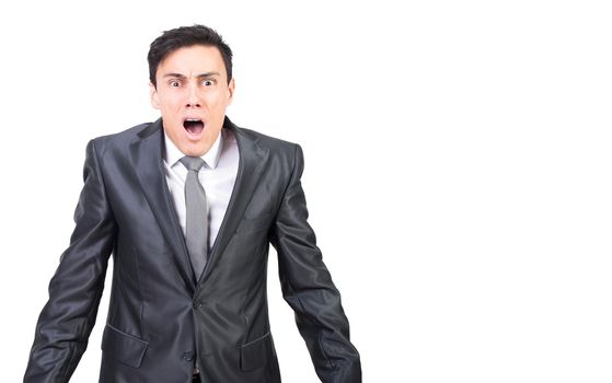 Scared young male entrepreneur in horror with dark hair in elegant suit and tie looking at camera with opened mouth