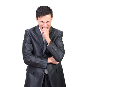 Confident male in formal costume biting fist while expressing nervous state against white background