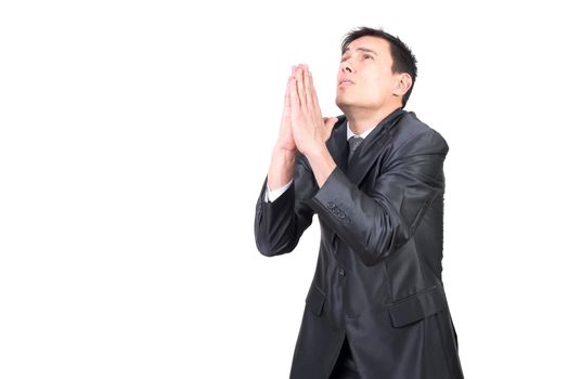 Handsome male entrepreneur in classy outfit praying and looking up while standing against white background