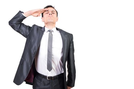 Serious male soldier in formal suit making salute gesture with hand and looking at camera isolated on white background in studio