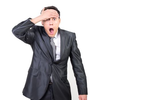 Astonished male in formal outfit touching forehead and looking at camera with opened mouth isolated on white background in studio