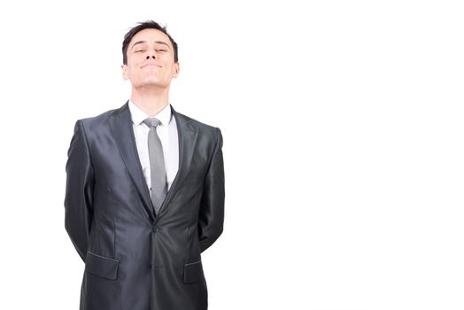 Successful male in elegant suit looking at camera with smile while standing with hands behind back isolated on white background