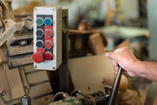 person controlling machinery in a factory, foreground, unfocused background