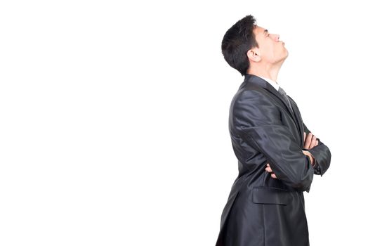 Side view of male office worker in formal suit standing with crossed arms and looking away with discontent face in studio against white background