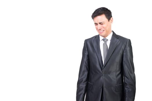 Dissatisfied male entrepreneur with black hair in formal suit crying with closed eyes while standing isolated on white background in studio
