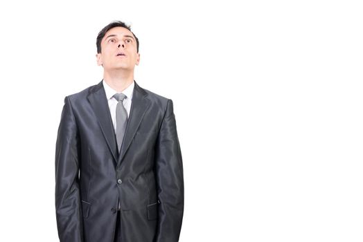 Handsome abducted male wearing elegant formal suit and tie looking up while standing on white background