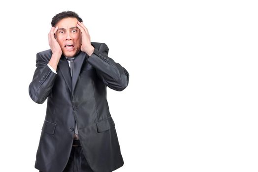 Shocked young male entrepreneur with dark hair in formal outfit gabbing head and looking at camera with scared grimace against white background