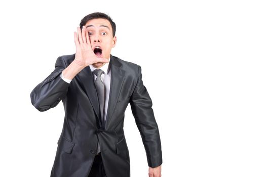 Astonished adult handsome surprised male in formal outfit talking shocking news by secret while standing against white background