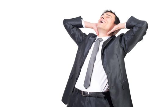 Delighted relaxed male entrepreneur with closed eyes and dark hair wearing black formal suit touching neck and stretching against white background
