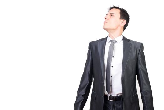 Dignified young male entrepreneur with dark hair in elegant suit and tie looking away with confidence against white background
