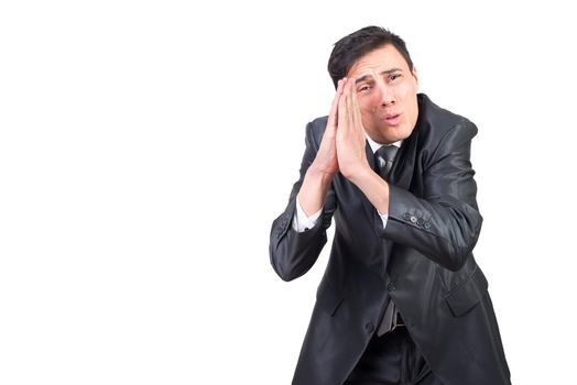 Serious adult male wearing black formal suit supplicating with clasped hands and looking at camera against white background