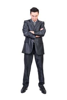 Full length of angry male entrepreneur in suit standing with crossed hands and feeling offended on white isolated background