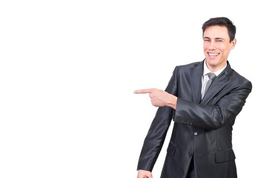 Happy smiling male leader in formal suit pointing aside with finger and looking at camera against white background