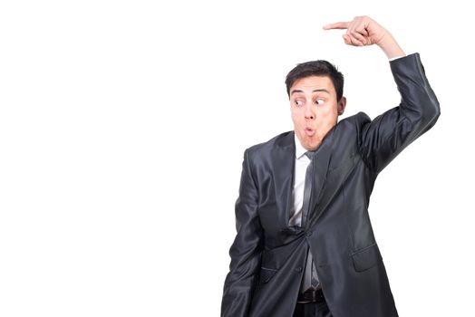 Mid shot of astonished male in elegant suit pointing aside while promoting ad isolated on white background in light studio