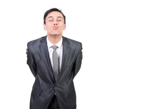 Romantic male in elegant suit leaning forward and looking at camera while sending air kiss with pouting lips isolated on white background in studio