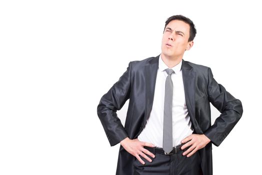 Focused confident man in elegant suit squinting eyes while thinking over issue standing against white background