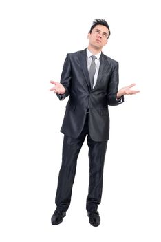 Full body of uninterested man in elegant suit looking up with palms up while standing isolated on white background in studio