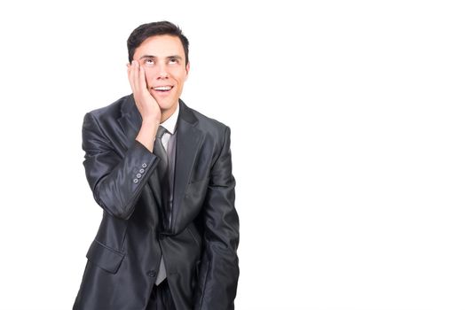 Cheerful male in elegant suit touching face with hand and expressing pleasure standing against white background