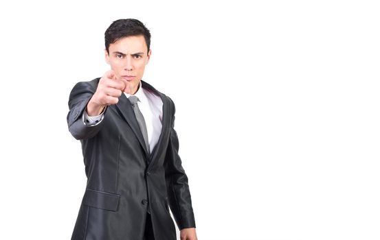 Handsome serious male entrepreneur in formal suit and tie pointing at camera while standing against white background