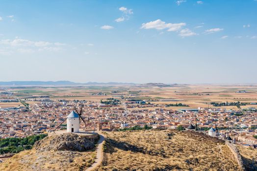 Panoramic photo of the windmills of Consuegra with a village in the background in Toledo, Spain.