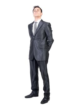 Full body of stringent male in formal suit looking at camera with hands behind back isolated on white background in studio