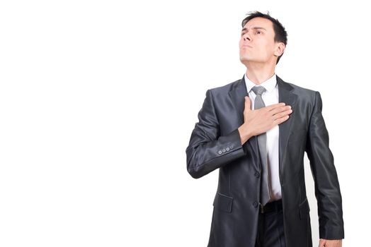 Confident male patriot keeping hand on chest as gesture of responsibility and pledge of allegiance to state while standing in studio against white background