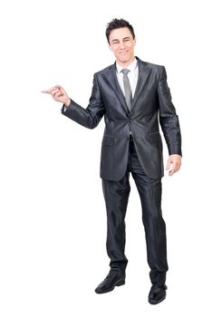Full body of positive male in formal suit pointing aside and looking at camera while promoting ad isolated on white background