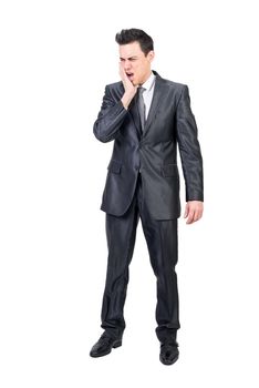 Full body of unwell man in formal suit touching cheek while suffering from toothache isolated on white background in studio
