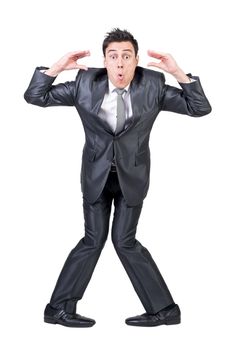 Full length of funny young male employee with dark hair making face and gesturing against white background