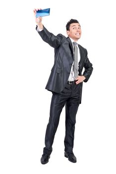 Comic male entrepreneur wearing classy suit taking self shot on mobile phone against white isolated background