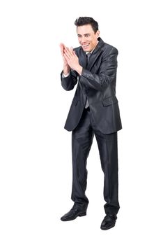 Smiling scheming male entrepreneur in suit making evil plans and rubbing hands while standing on white background