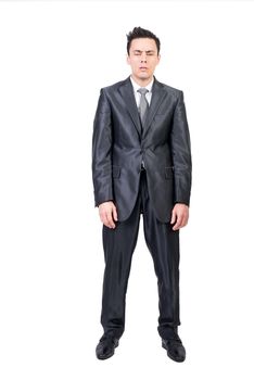 Full length of tired male entrepreneur in classy suit standing against white background and looking at camera