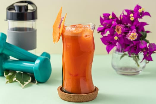 Refreshing healthy drink in long glass cup on light green background