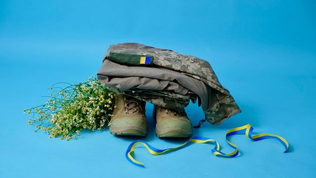 Military uniform of a Ukrainian soldier of the Armed Forces of Ukraine 2022 on an isolated blue background in a close-up studio in the war with Russia. Clothes of a true hero