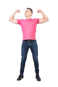 Full length of young strong male model with dark hair in casual outfit showing biceps and looking at camera with confidence against white background