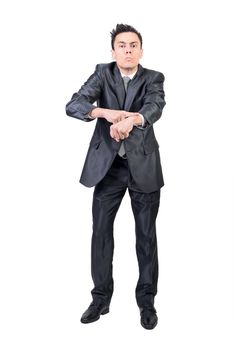 Full body of strict male boss in suit pointing at wrist and showing being late sign while looking at camera against white background