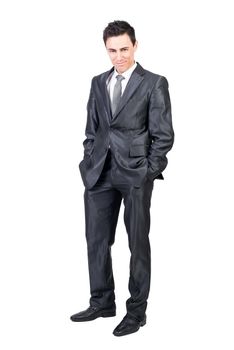Full body of seductive male in formal suit looking at camera with smirk while standing with hands in pockets isolated on white background in studio