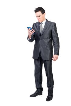 Full body of unsatisfied well dressed male entrepreneur reading unpleasant news on cellphone against white background