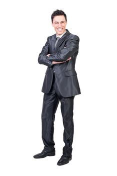 Full body of satisfied male entrepreneur in formal outfit standing with crossed arms and laughing at camera with wide smile against white background