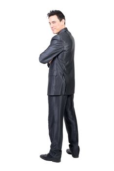 Full body of content male in formal suit looking over shoulder at camera with squinting eyes isolated on white background