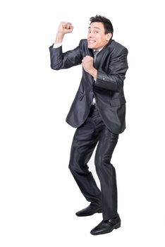 Full body of gleeful male in elegant suit looking at camera with clenched fists while celebrating isolated on white background