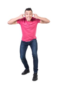 Funny male model in casual wear making narrow eyes and smiling widely on white background