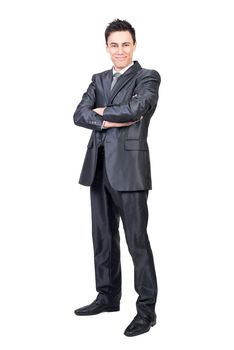 Full body of optimistic male in formal suit looking at camera with smile while standing with crossed arms isolated on white background