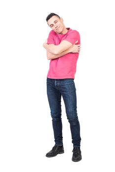 Merry male in casual clothes embracing shoulders and looking at camera with smile while expressing love isolated on white background