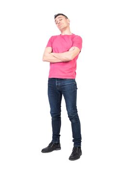 Full length proud male in jeans and pink t shirt folding arms and looking at camera isolated on white background