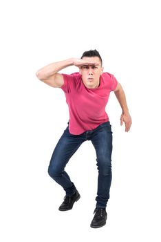 Full length male touching forehead and looking at camera while trying to descry objects in distance against white background