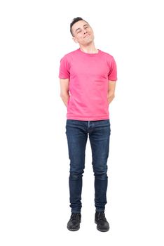 Full body of positive male model in casual outfit looking at camera with smile while standing with hands behind back isolated on white background